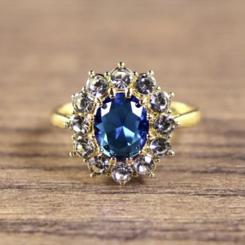 Damenring, goldfarben, Hauptstein Blau mit kleinen weißen Steinen umkreist