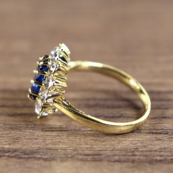 Preview: Damenring, goldfarben, Hauptstein Blau mit kleinen weißen Steinen umkreist