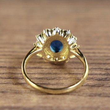 Preview: Damenring, goldfarben, Hauptstein Blau mit kleinen weißen Steinen umkreist