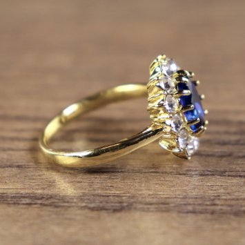 Preview: Damenring, goldfarben, Hauptstein Blau mit kleinen weißen Steinen umkreist